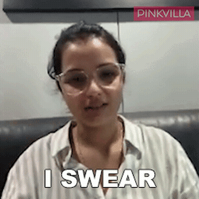 A Woman Wearing Glasses Says " I Swear " In Front Of A Pinkvilla Logo GIF