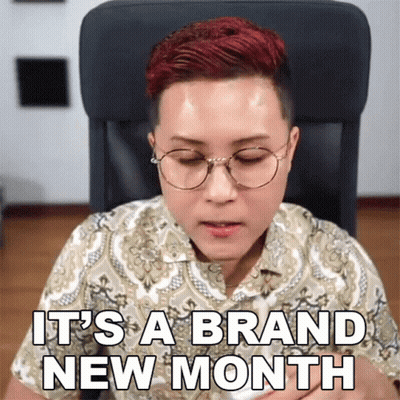 A Woman Wearing Glasses Says It 'S A Brand New Month While Sitting In A Chair GIF