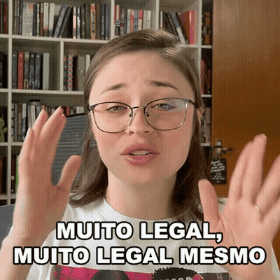 A Woman Wearing Glasses Says Muito Legal Muito Legal Mesmo In Front Of A Bookshelf GIF