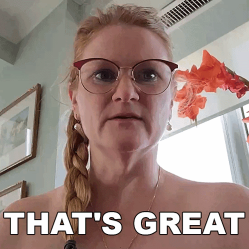 A Woman Wearing Glasses Says That 'S Great In Front Of A Window GIF