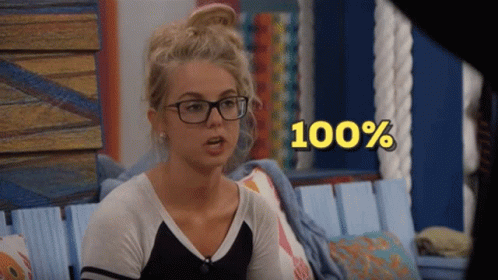 A Woman Wearing Glasses Sits In A Chair With The Words 100 % Above Her Head GIF
