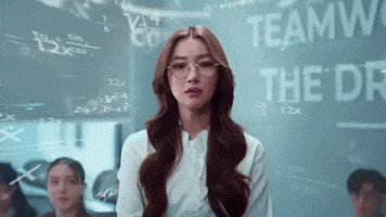 A Woman Wearing Glasses Stands In Front Of A Blackboard That Says Teamwork GIF