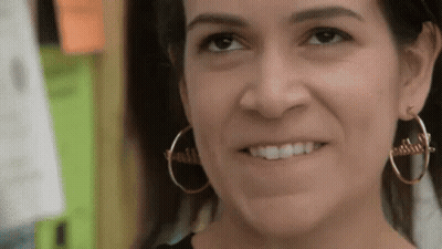 A Woman Wearing Gold Hoop Earrings With The Word Faith On Them GIF