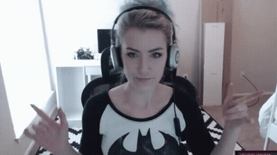 A Woman Wearing Headphones And A Batman T-Shirt Is Giving The Middle Finger GIF