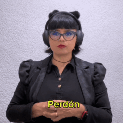 A Woman Wearing Headphones And A Black Jacket Says Perdon GIF