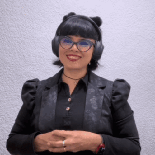 A Woman Wearing Headphones And A Black Jacket Smiles For The Camera GIF