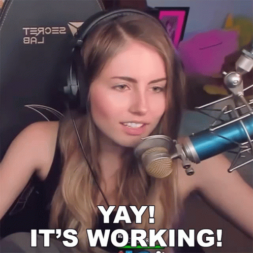 A Woman Wearing Headphones And A Blue Microphone Says Yay It 'S Working GIF