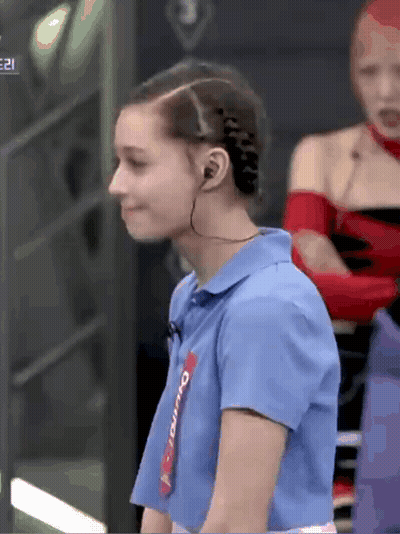 A Woman Wearing Headphones And A Blue Shirt With The Word Overdo On The Sleeve GIF