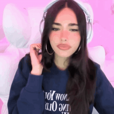 A Woman Wearing Headphones And A Blue Sweatshirt That Says Toy Wow GIF