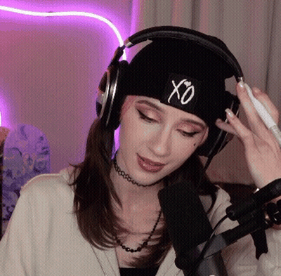 A Woman Wearing Headphones And A Hat With The Letter Xo On It GIF
