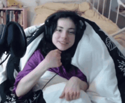 A Woman Wearing Headphones And A Purple Shirt Is Wrapped In A Blanket GIF