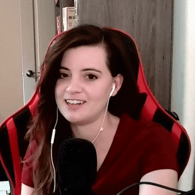 A Woman Wearing Headphones And A Red Shirt Is Sitting In A Red Chair . GIF