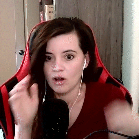 A Woman Wearing Headphones And A Red Shirt Is Sitting In Front Of A Microphone And Making A Funny Face . GIF