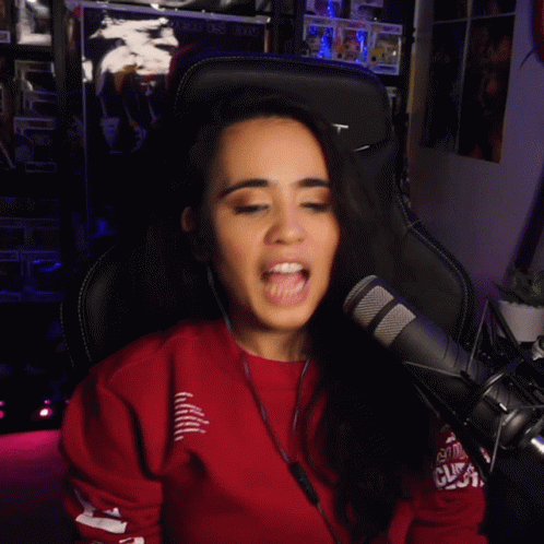 A Woman Wearing Headphones And A Red Sweatshirt With The Word Rt On The Sleeve GIF