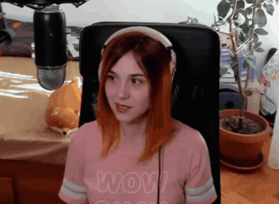 A Woman Wearing Headphones And A Shirt That Says Wow Is Sitting In Front Of A Microphone GIF