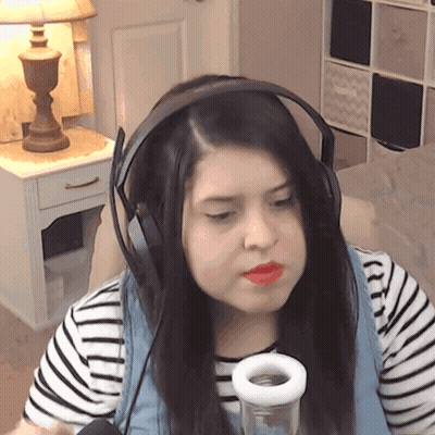 A Woman Wearing Headphones And A Striped Shirt Is Holding A Glass GIF