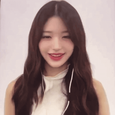 A Woman Wearing Headphones And A White Top Smiles GIF