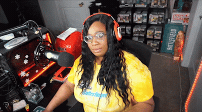A Woman Wearing Headphones And A Yellow Shirt That Says Matterfinger Is Sitting In Front Of A Microphone GIF