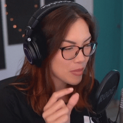 A Woman Wearing Headphones And Glasses Is Making A Funny Face GIF