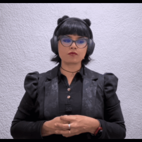 A Woman Wearing Headphones And Glasses Is Making A Gesture With Her Hands GIF