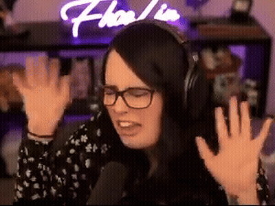 A Woman Wearing Headphones And Glasses Is Sitting In Front Of A Microphone . GIF