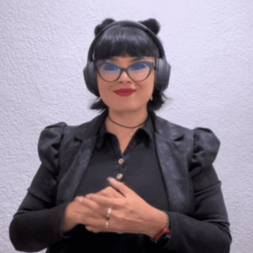 A Woman Wearing Headphones And Glasses Is Smiling For The Camera GIF