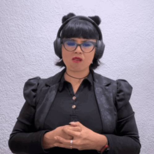 A Woman Wearing Headphones And Glasses Looks Angry GIF