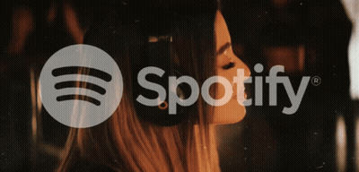 A Woman Wearing Headphones And The Spotify Logo GIF