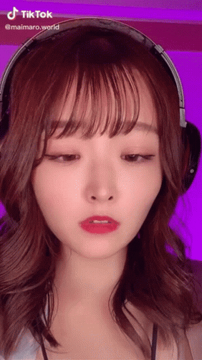 A Woman Wearing Headphones Has A Tiktok Sticker On Her Face GIF