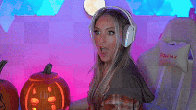 A Woman Wearing Headphones Holds A Carved Pumpkin GIF