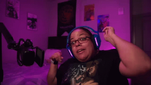 A Woman Wearing Headphones Is Dancing In Front Of A Poster That Says Targaryen . GIF