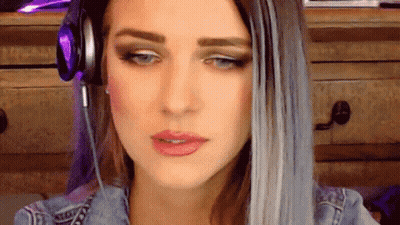 A Woman Wearing Headphones Is Looking At The Camera GIF
