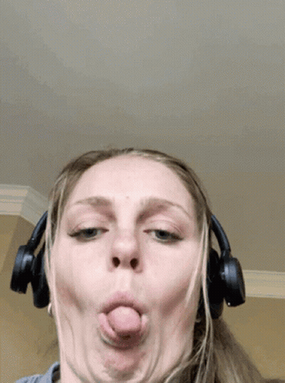 A Woman Wearing Headphones Is Making A Funny Face GIF