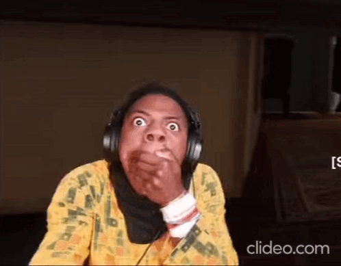 A Woman Wearing Headphones Is Making A Funny Face While Covering Her Mouth . GIF
