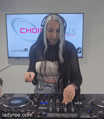 A Woman Wearing Headphones Is Playing Music In Front Of A Screen That Says Choir GIF