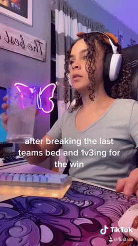 A Woman Wearing Headphones Is Sitting At A Desk In Front Of A Computer And A Sign That Says " Good All " GIF