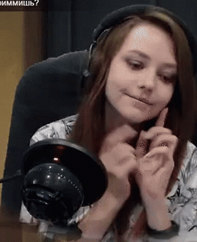 A Woman Wearing Headphones Is Sitting At A Table With A Microphone In Front Of Her GIF