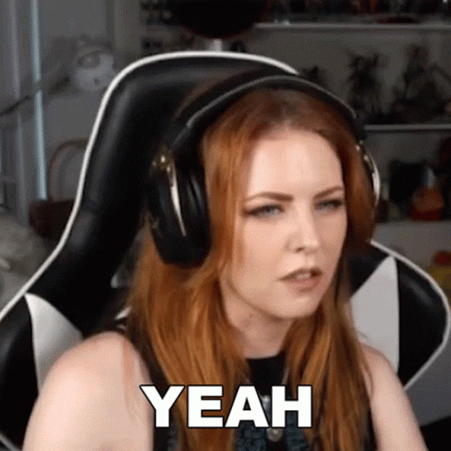 A Woman Wearing Headphones Is Sitting In A Chair And Says Yeah GIF