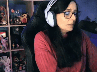 A Woman Wearing Headphones Is Sitting In A Chair . GIF