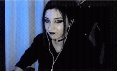 A Woman Wearing Headphones Is Sitting In Front Of A Computer . GIF