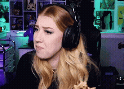 A Woman Wearing Headphones Is Sitting In Front Of A Green Wall GIF
