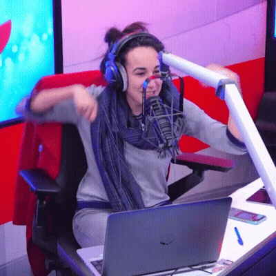A Woman Wearing Headphones Is Sitting In Front Of A Microphone And A Laptop GIF