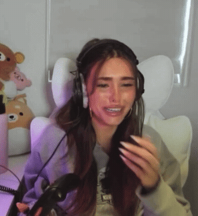 A Woman Wearing Headphones Is Sitting In Front Of A Microphone In A Chair . GIF