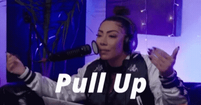 A Woman Wearing Headphones Is Sitting In Front Of A Microphone In A Room . GIF