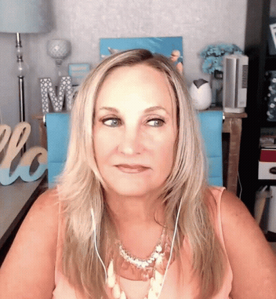 A Woman Wearing Headphones Is Sitting In Front Of A Welcome Sign GIF