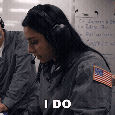 A Woman Wearing Headphones Is Sitting In Front Of A White Board That Says Time GIF