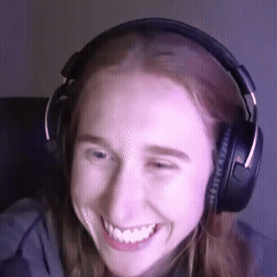 A Woman Wearing Headphones Is Smiling And Looking At The Camera GIF