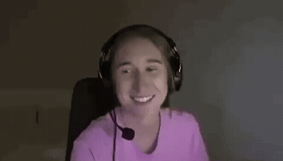 A Woman Wearing Headphones Is Smiling And Making A Funny Face . GIF