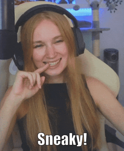 A Woman Wearing Headphones Is Smiling And Says Sneaky On The Bottom GIF