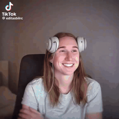 A Woman Wearing Headphones Is Smiling In A Tiktok GIF